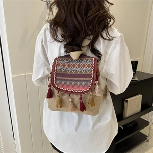 Sac à dos bohème en toile avec tissage ethnique et glands colorés porté par un modèle