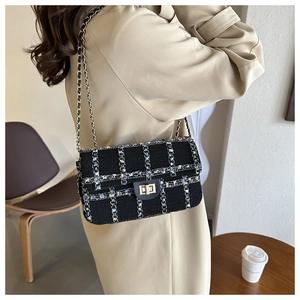 Détail d'un sac à bandoulière en tweed avec chaîne dorée et fermoir métallique tournant