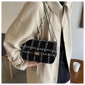 Détail du sac bandoulière en tweed à carreaux noirs avec fermoir pivotant doré