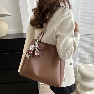 Brown large capacity tote bag with woven strap and silk scarf on a model