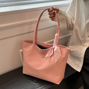 Detailed view of pink tote bag featuring elegant striped silk scarf ribbon handle