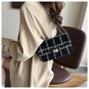 Sac bandoulière en tweed avec chaîne porté par un mannequin pour un look urbain chic