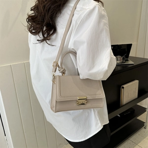 Elegant beige croc-embossed square crossbody bag with gold metal buckle and knotted handle
