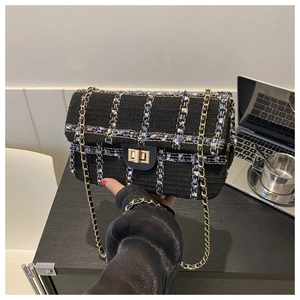 Détail du sac à bandoulière en tweed avec fils bleus et dorés et chaîne dorée