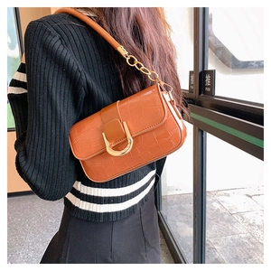 Detail view of brown crocodile embossed PU leather bag with golden horseshoe buckle