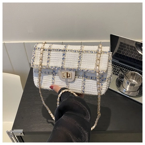Détail du sac bandoulière en tweed avec texture bleu et blanc et fermoir doré