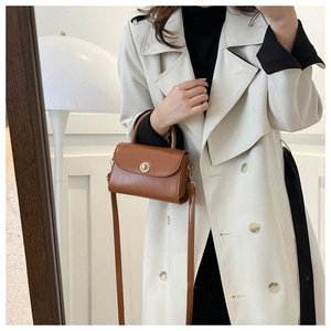 Brown vintage leather crossbody bag with gold twist lock shown in lifestyle setting