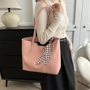 Pink minimalist faux leather tote bag with checkerboard silk scarf decoration in cozy room