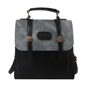 Dual-material backpack with blue denim flap and black leather body featuring gold buckles