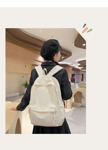 Rückansicht eines minimalistischen cremefarbenen Rucksacks mit geflochtenen Kordelzügen