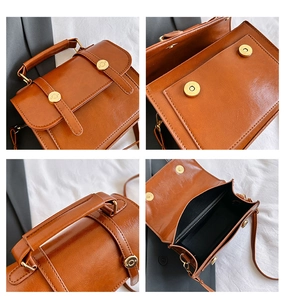 Dettagli della borsa in pelle marrone vintage con chiusura magnetica dorata e finitura lucida