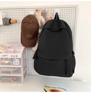 Detail eines schwarzen Nylonrucksacks mit gewebten Reißverschlüssen und Seitengurten