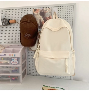 Detailansicht cremefarbener Nylon-Rucksack mit Seil-Reißverschlüssen auf Stecktafel