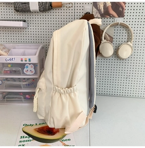 Detailansicht des beigen Rucksacks mit elastischer Seitentasche und gepolsterten Trägern