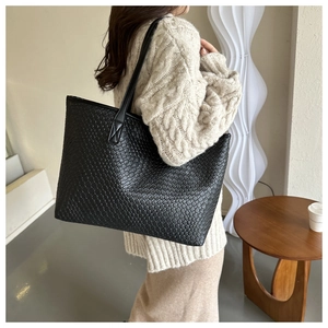 Dettaglio della borsa tote nera intrecciata con grande capacità e trama in pelle elegante