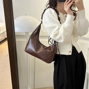 Minimalist dark brown half-moon underarm bag with unique pleated shoulder strap detail
