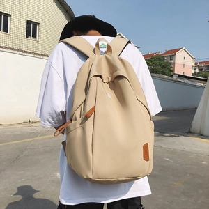 Minimalist beige nylon backpack for women with brown leather details on street
