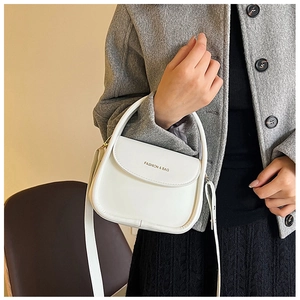 White mini square handbag with top handle and detachable strap on a grey wool coat