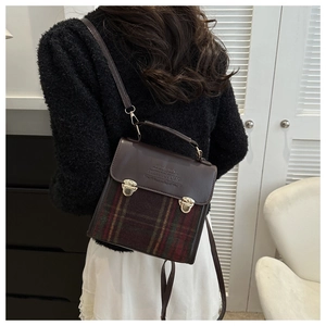 Detail view of a vintage plaid crossbody bag worn by a model in a cozy winter setting