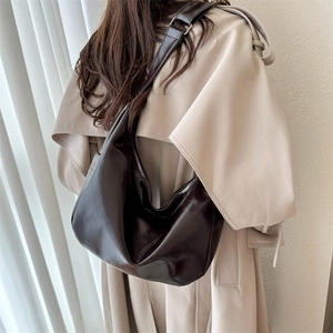 Minimalist large capacity dark brown leather shoulder bag shown in a warm lifestyle scene