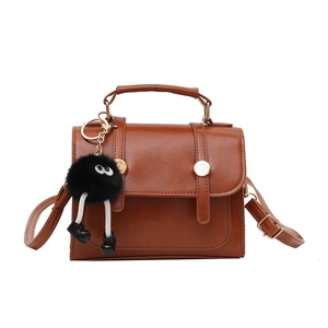 Borsa a mano vintage marrone in ecopelle con ciondolo pompon nero e fibbia metallica