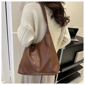 Brown faux leather large tote bag detail showing wide shoulder strap and soft texture