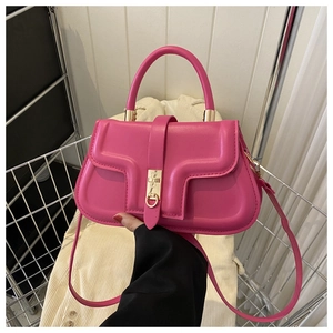 Détail du sac à main en cuir rose vif avec rabat géométrique et fermoir doré rotatif