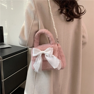 Sac à main chic en peluche rose avec un grand nœud blanc et une chaîne de perles élégante