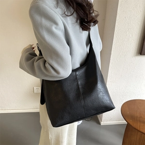 Large black textured faux leather tote bag with a minimalist design for daily commuting
