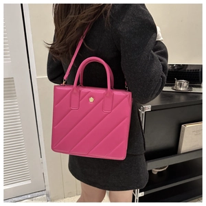 Detail view of pink quilted handbag with gold flower logo on a modern bag style