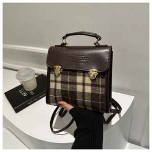 Detail of vintage plaid mini backpack with leather trim and golden buckle closure