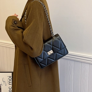 Sac bandoulière classique en cuir noir matelassé avec chaîne dorée sur mannequin