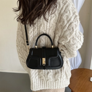 Sac à main chic en cuir noir mat avec fermoir doré et détails de design texturés