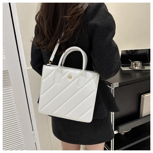 Chic white quilted leather handbag with gold flower logo shown in a professional setting