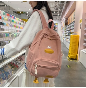 Detailed texture of pink corduroy backpack featuring 3D cartoon duck features and soft fabric