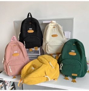 Detail view of colorful corduroy backpacks with cute duck facial features and webbed feet