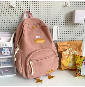 Close-up of pink corduroy backpack featuring a cartoon duck design and premium embroidery