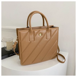 Close-up of brown quilted handbag featuring floral gold hardware and textured finish