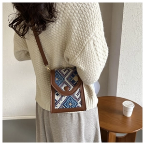 Détail d'un sac bandoulière jacquard bohème avec bordure en cuir marron et bouton-pression