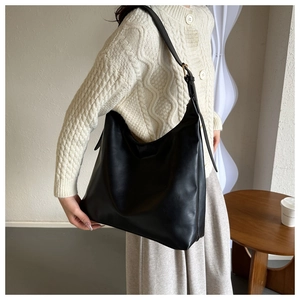 Macro shot of minimalist black PU leather tote bag with soft matte texture and adjustable strap