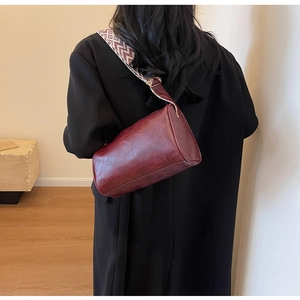 Sac bandoulière cylindre bordeaux en cuir avec bandoulière tissée motif ethnique