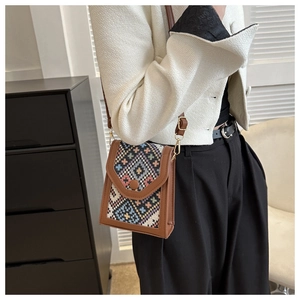Détail du sac bandoulière bohème à motif géométrique tissé avec garniture en cuir brun