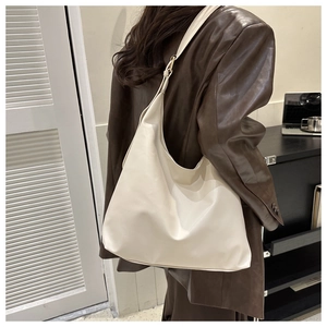 Detail of the minimalist off-white hobo shoulder bag with wide strap and PU texture