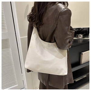 Rear view of a model wearing a large beige hobo tote bag for casual daily use