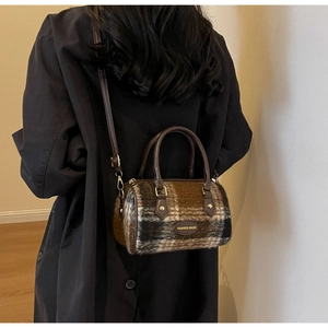 Sac à main écossais marron sur manteau noir montrant le tissu et la bandoulière
