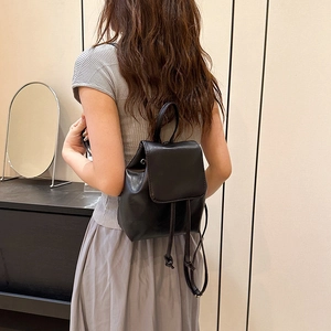 Chic black leather backpack for women with flap and drawstring closure in casual style