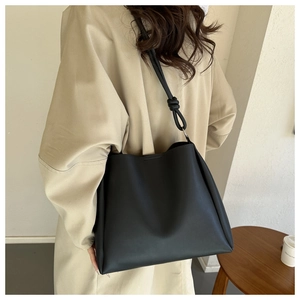 Détail d'un grand sac cabas noir minimaliste avec une poignée nouée sur l'épaule