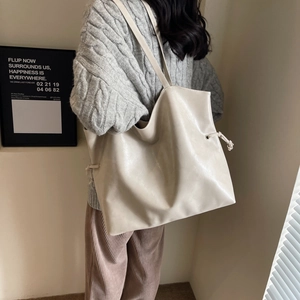 Minimalist large cream leather tote bag with drawstring detail for daily commute