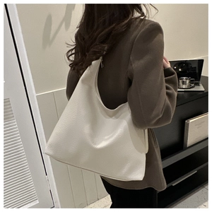 Close-up of ivory white hobo tote bag with lychee grain texture and metal zipper