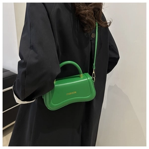 Détail de la base ondulée et du texte Fashion doré sur ce sac vert en similicuir